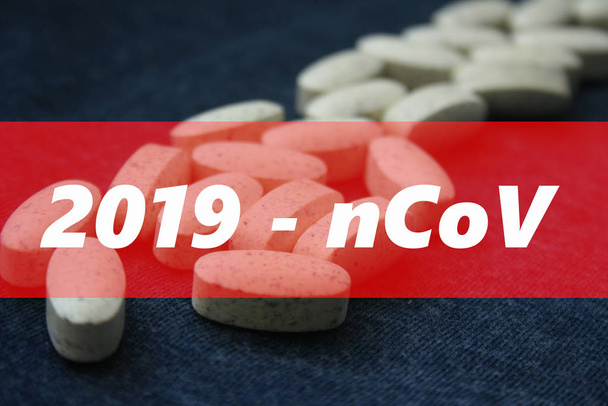 Word coronavirus with tablets and pills on dark blue background. Coronavirus epidemic concept. - Φωτογραφία, εικόνα