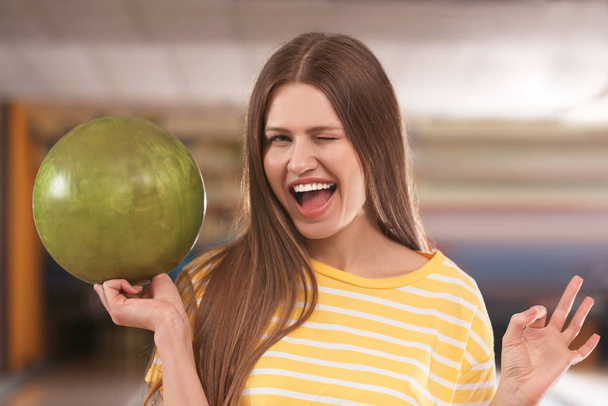 Young woman with ball in bowling club - Foto, Imagen