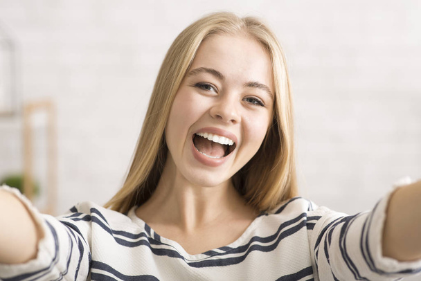 Emocionální blondýny hezká dívka přičemž selfie sám doma - Fotografie, Obrázek