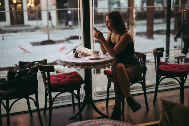 Woman playing with smartphone in cafe - Zdjęcie, obraz