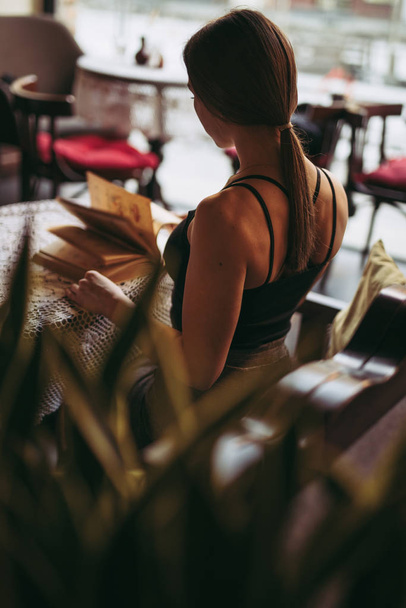 Young woman reading book in cafe - Photo, Image