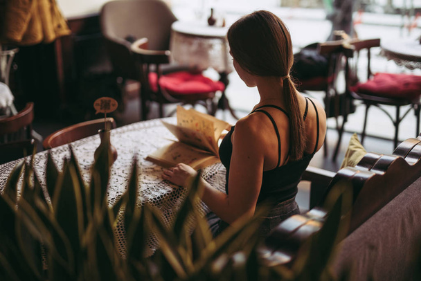 カフェで本を読む若い女性 - 写真・画像