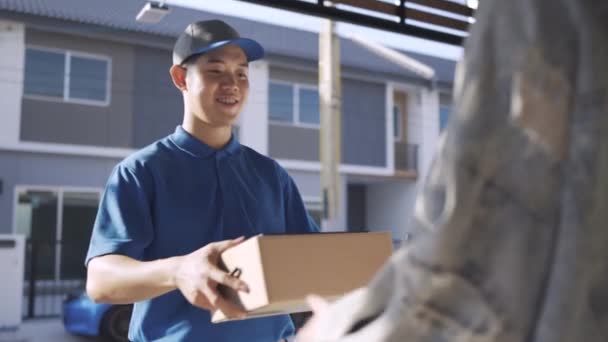 Delivery man sending parcel postal package order comes to customer at front house the open doorway, Delivery package service his smiling happy. Shot on 4K UHD Footage cinematic  - Πλάνα, βίντεο
