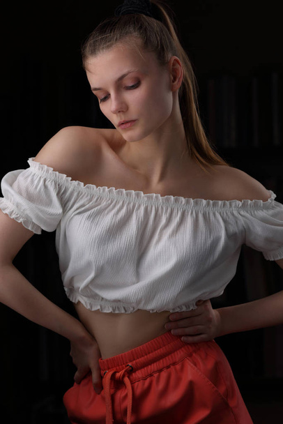 Beautiful girl in a white blouse and red shorts - Photo, Image