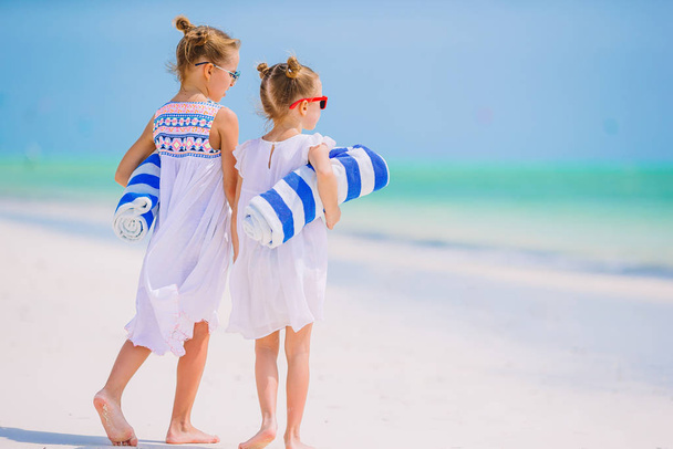 Adorable little girls have fun together on white tropical beach - Фото, изображение