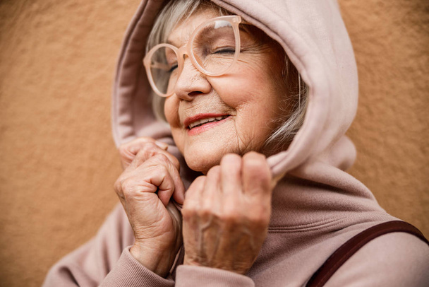 Happy mature woman in hood and glasses stock photo - Fotografie, Obrázek