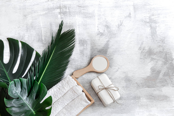 Spa. Body care items on a white background with tropical leaves. - Foto, afbeelding