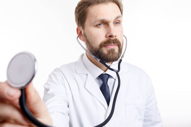 Un medico barbuto attento in bianco Auscultating
 - Foto, immagini