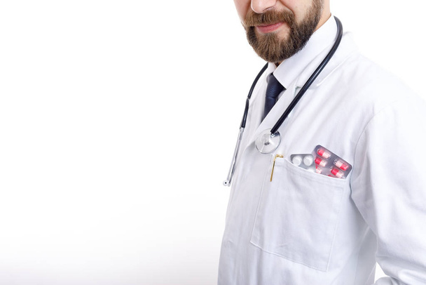 Brodaty lekarz w Smock z różnych pigułek i tabletek w kieszeni - Zdjęcie, obraz