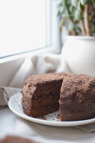 homemade layer chocolate wet cake with fudge frosting on windowsill background - Photo, image