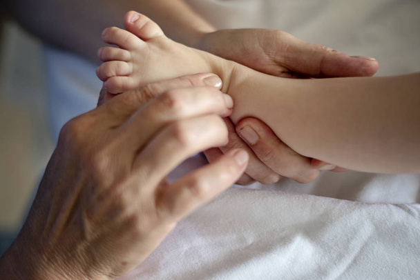 Baby having foot massage in a rehabilitation center. - Фото, зображення