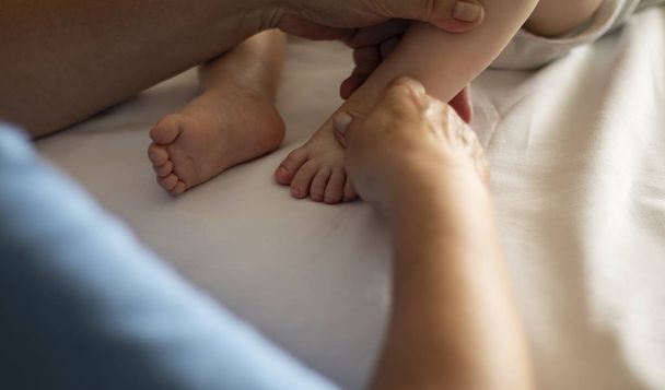 Bebê tendo massagem nos pés em um centro de reabilitação
.  - Foto, Imagem