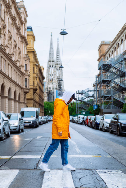 женщина пересекает улицу старые башни церкви на заднем плане
 - Фото, изображение