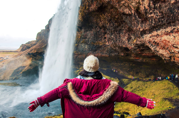 Nainen nauttii vierailevat vesiputous näkymä Islannissa
 - Valokuva, kuva