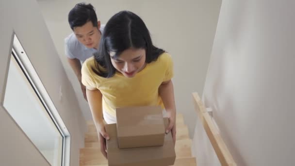 Couple family holding parcel from shopping online internet walking on the staircase for open package delivery surprise gift order at home happy smile. Slow motion Footage cinematic, Arc shot - Footage, Video