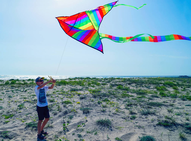 Een jongen lanceert een vlieger aan de zeekust . - Foto, afbeelding