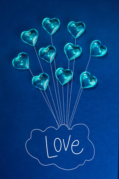 Valentýn v pozadí. Balónek ze srdcí, písmen, slovo láska. Modrá srdce na tmavomodrém pozadí. Minimalismus. symbol lásky gayů - Fotografie, Obrázek