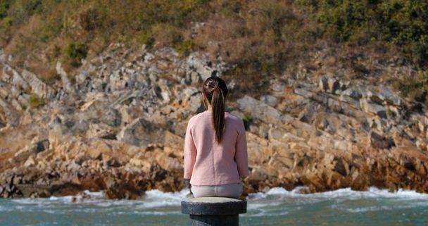 Žena sedí na molu a dívá se na moře - Fotografie, Obrázek