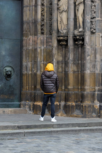 Neurenberg, Duitsland. Een jongeman onderzoekt de details van de Katholieke kerk Frauenkirche in Neurenberg. Een interessante reis naar Duitsland. - Foto, afbeelding