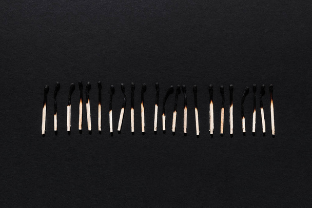 Row of burnt matches on a dark background. - Fotoğraf, Görsel