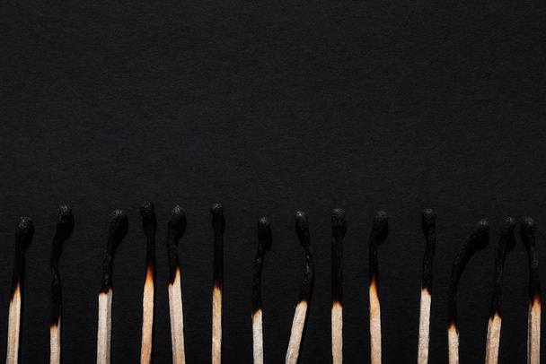 Row of burnt matches on a dark background. - Фото, изображение