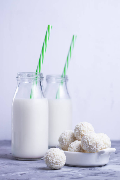 milk with white coconut sweets on a white background - Valokuva, kuva
