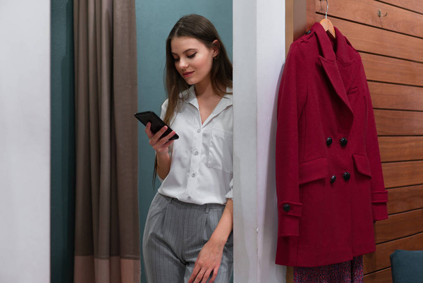 One caucasian women in a fashion boutique choose clothes buy for autumn season. - Zdjęcie, obraz