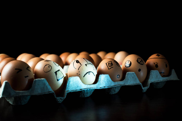 Эмоциональные куриные яйца в подносе. Интересные гримасы нарисованные на
  - Фото, изображение