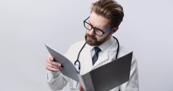 Medical expert in eyeglasses reading patient case - Footage, Video