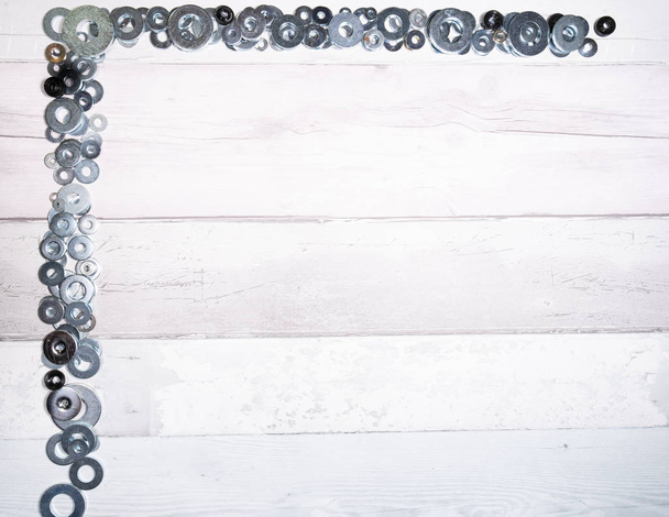 Set of different sizes of metal washers on an old wooden background. top view. - Foto, Imagem