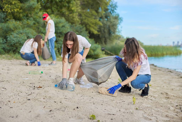Group of students with teacher in nature doing cleaning of plastic garbage - Fotó, kép