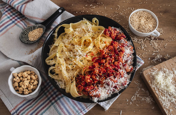 Bowl filled with pasta and textured soya, cheese, oregano and sesam. Perfect for vegetarian people. Rustic background scenery. - Fotoğraf, Görsel