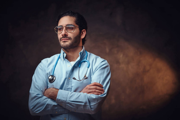 Πορτρέτο του έξυπνος όμορφος γιατρός πάνω από σκούρο φόντο. - Φωτογραφία, εικόνα