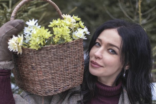 portrait of a young woman with a full basket of snowdrops. selective focus. closeup - Photo, Image