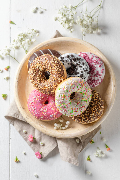 Sweet donuts with various types of toppings on white plate - Foto, Imagem