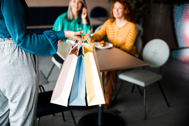 Woman holding shopping bags and meeting friends - Φωτογραφία, εικόνα