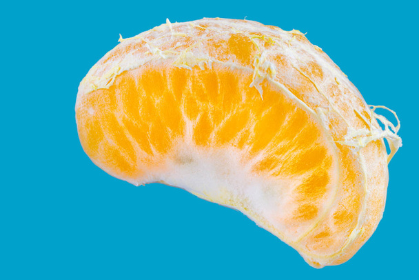 Řez z jednoho čerstvého mandarinky na modrém pozadí - Fotografie, Obrázek