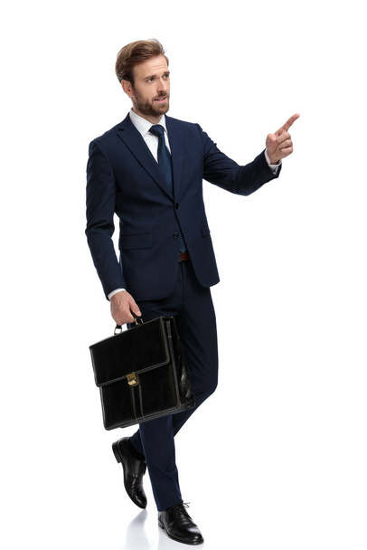 sexy young businessman pointing finger and holding suitcase - Φωτογραφία, εικόνα
