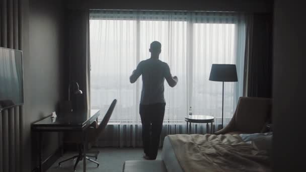 Un hombre se acerca a la ventana y abre las cortinas
 - Metraje, vídeo