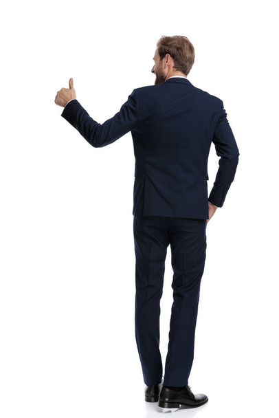 gelukkig zakenman in marine blauw pak maken duimen omhoog teken naar sid - Foto, afbeelding