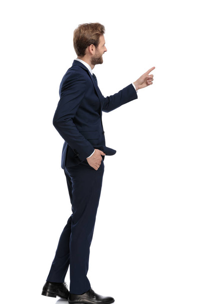 feliz hombre de negocios en traje azul marino señalando con el dedo
 - Foto, Imagen