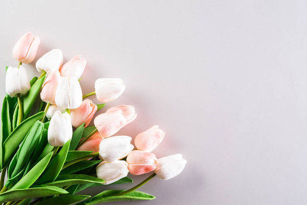 International Women 's Day concept. Roze en witte tulpen op grijs - Foto, afbeelding