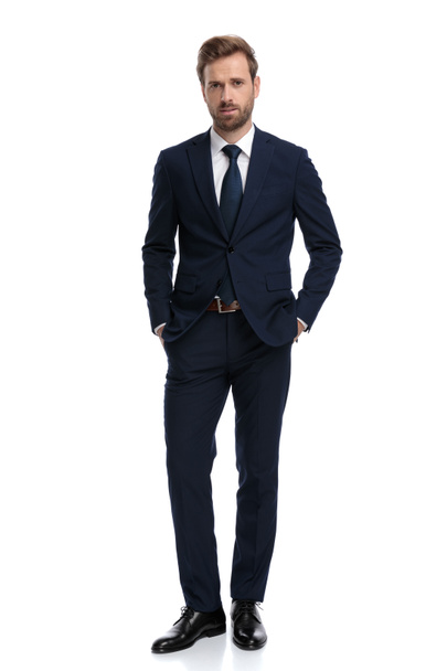 sexy young businessman in navy blue suit holding hands in pocket - Fotoğraf, Görsel