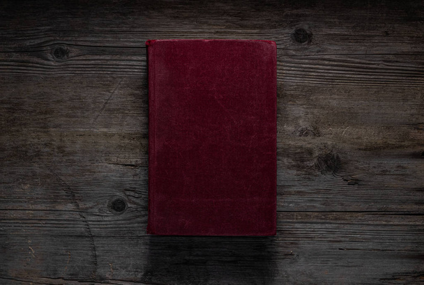 Closed book on vintage wooden background.  Old book on the woode - Foto, imagen