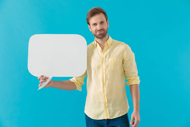 Positive casual man smiling and holding a speech bubble - Photo, Image