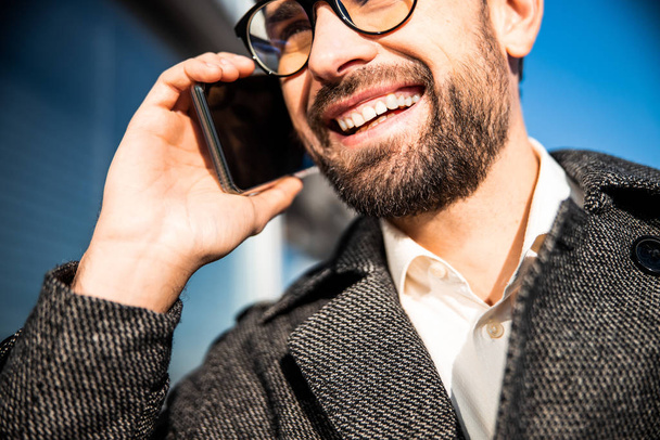 Cheerful man in eyeglasses using his gadget - Фото, изображение