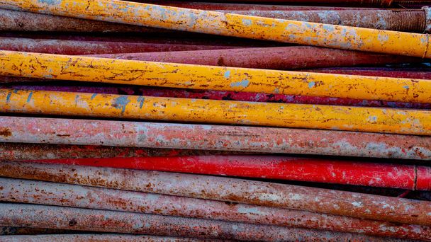 Background image of colorful scaffolding bar and wood used for construction stacked togeather - Fotoğraf, Görsel