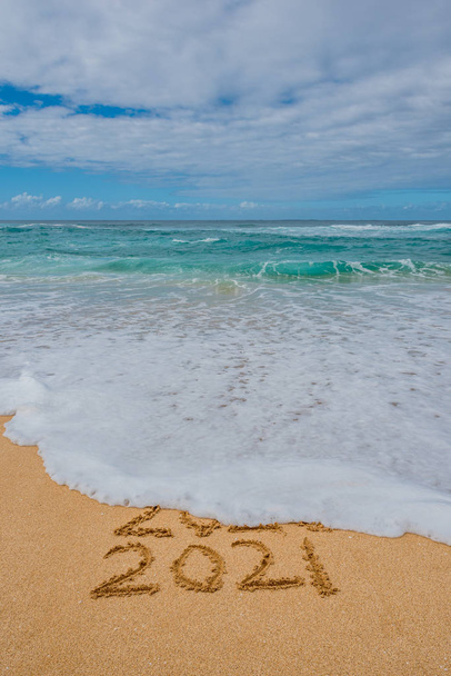 2020 2021 written in the sand with a wave erasing 2020- New Years concept - Zdjęcie, obraz