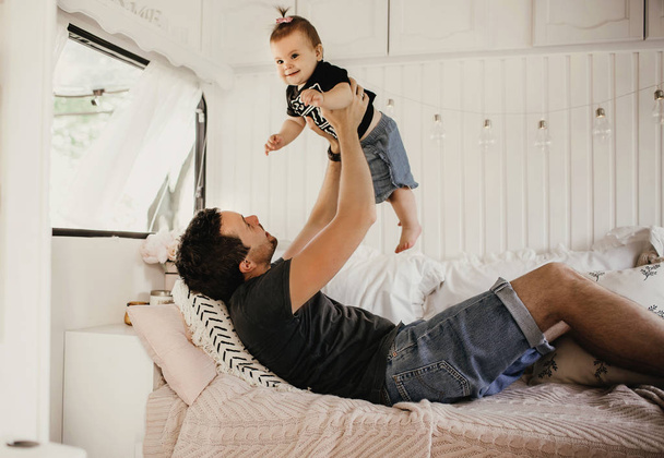 Father plays with daughter, happy child, father rejoices to little daughter, life in a motor home - Foto, imagen