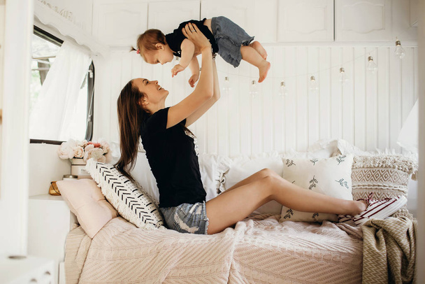 Anne kızıyla oynuyor, mutlu çocuk, anne küçük kızına seviniyor, karavanda yaşıyor. - Fotoğraf, Görsel